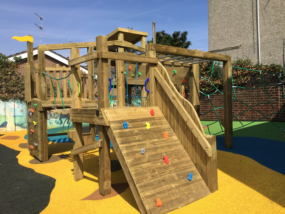 Wooden play climber with climbing wall